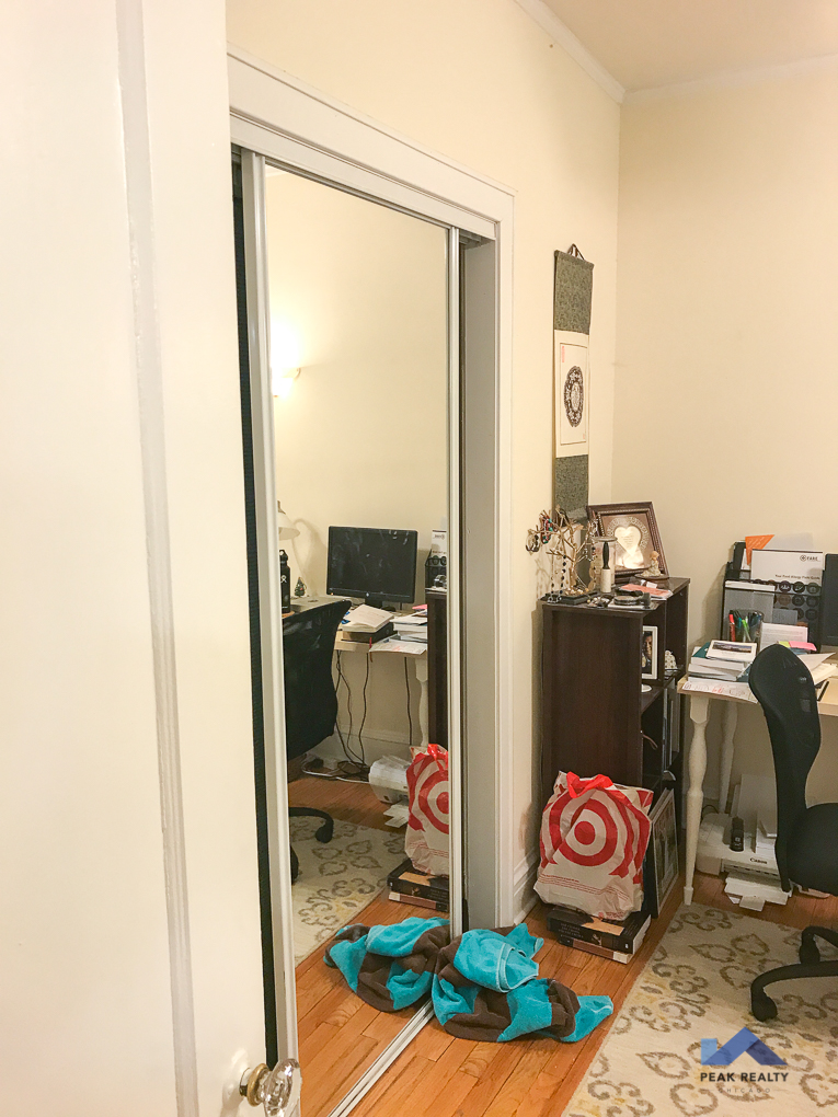 a room with a mirror and a desk and some clothes on the floor